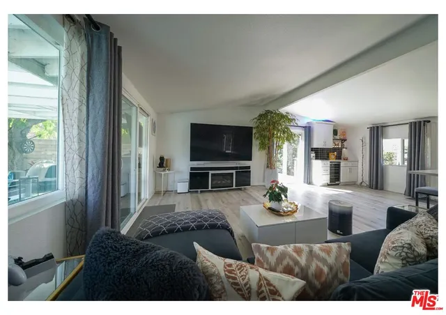 a living room with furniture a flat screen tv and a large window