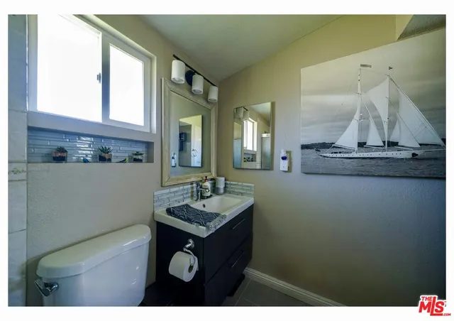 a bathroom with a sink a mirror and a toilet