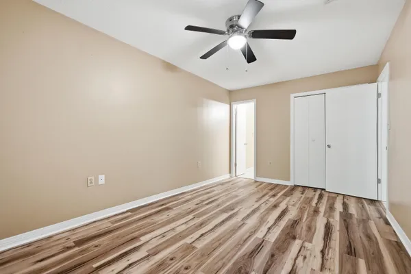 a view of a big room with wooden floor and a ceiling fan