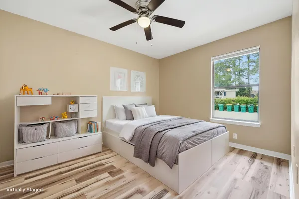 a bedroom with a large bed and a chandelier fan