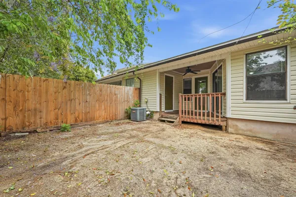 a view of a house with a fence and a tree