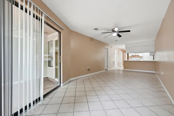 a view of an empty room and a kitchen