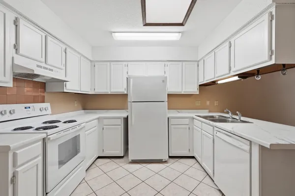 a kitchen with white cabinets and white appliances