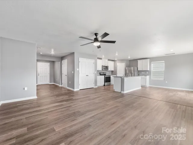 a view of a kitchen with wooden floor and a ceiling fan