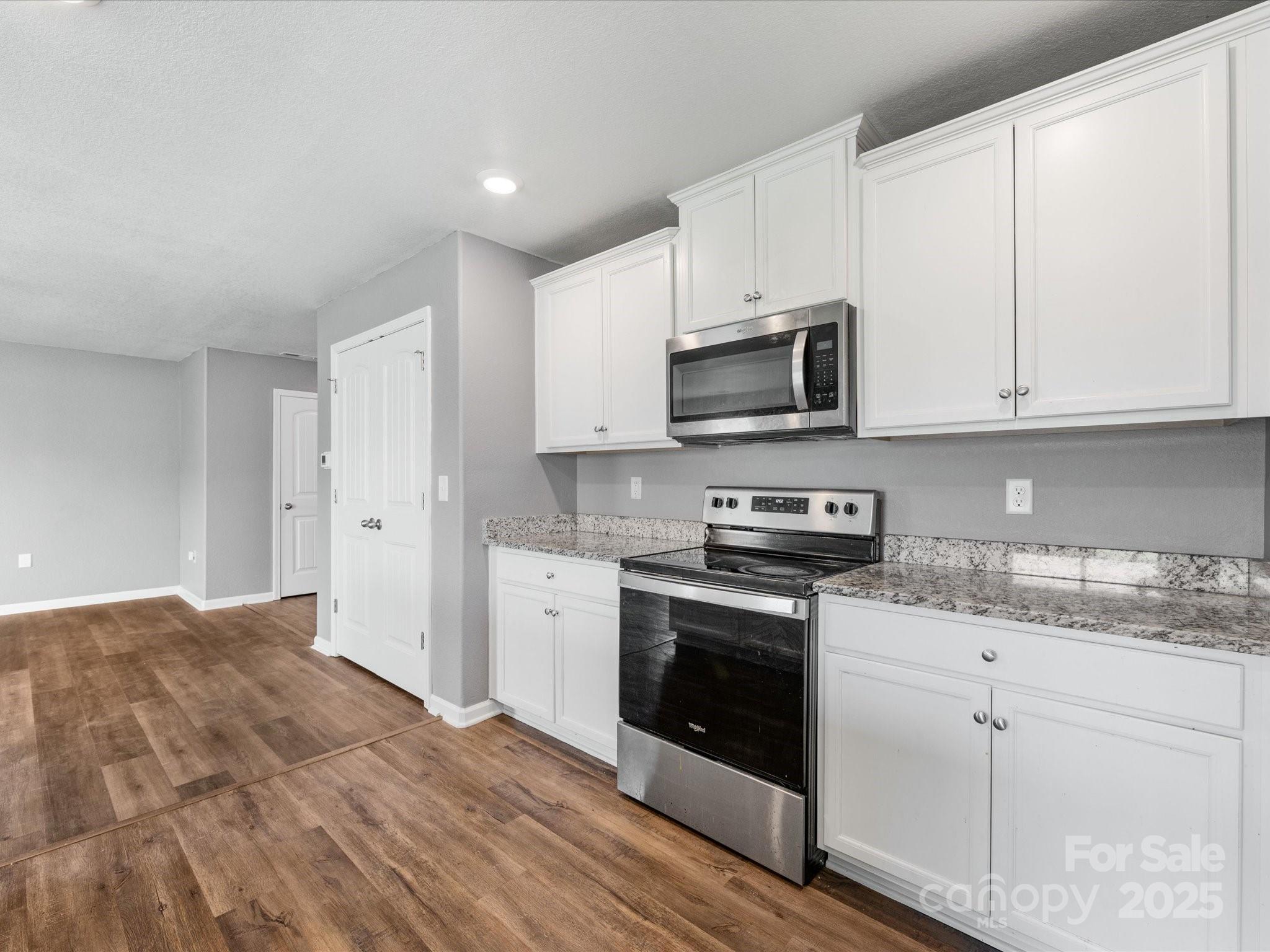 9136 Creedmore Hills Drive Charlotte, NC 28214 - Photo 16 of 48 a kitchen with stainless steel appliances granite countertop a stove a sink and white cabinets