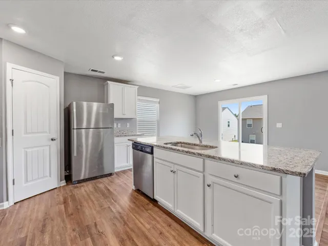 a kitchen with granite countertop a refrigerator and a sink