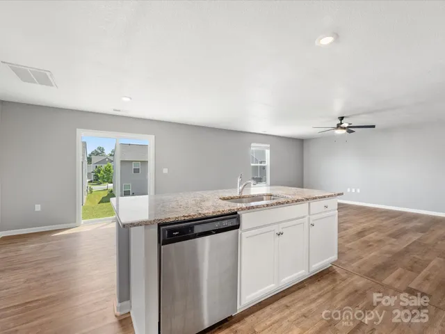 a kitchen with granite countertop a sink and cabinets