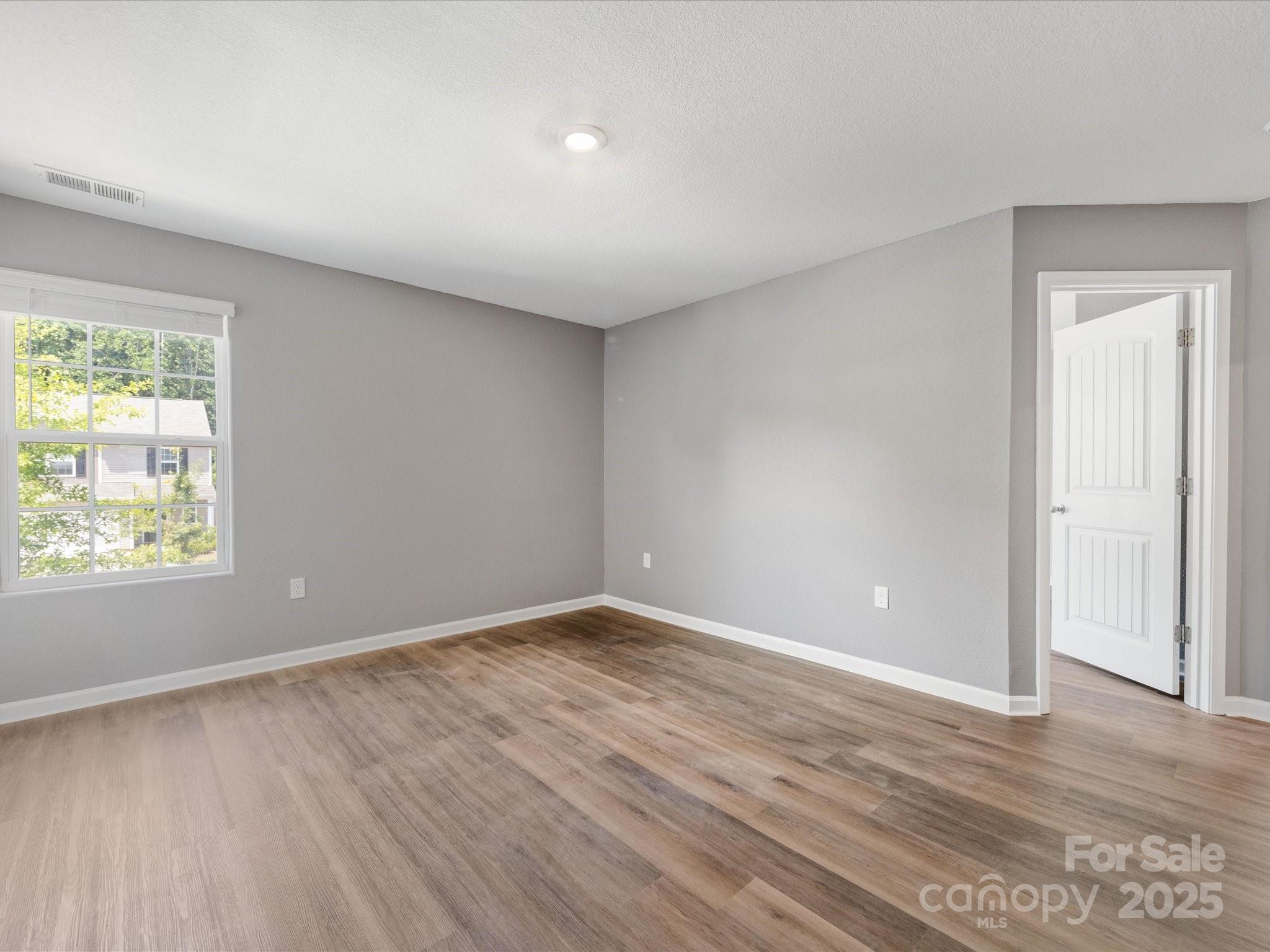 9136 Creedmore Hills Drive Charlotte, NC 28214 - Photo 25 of 48 an empty room with wooden floor and windows