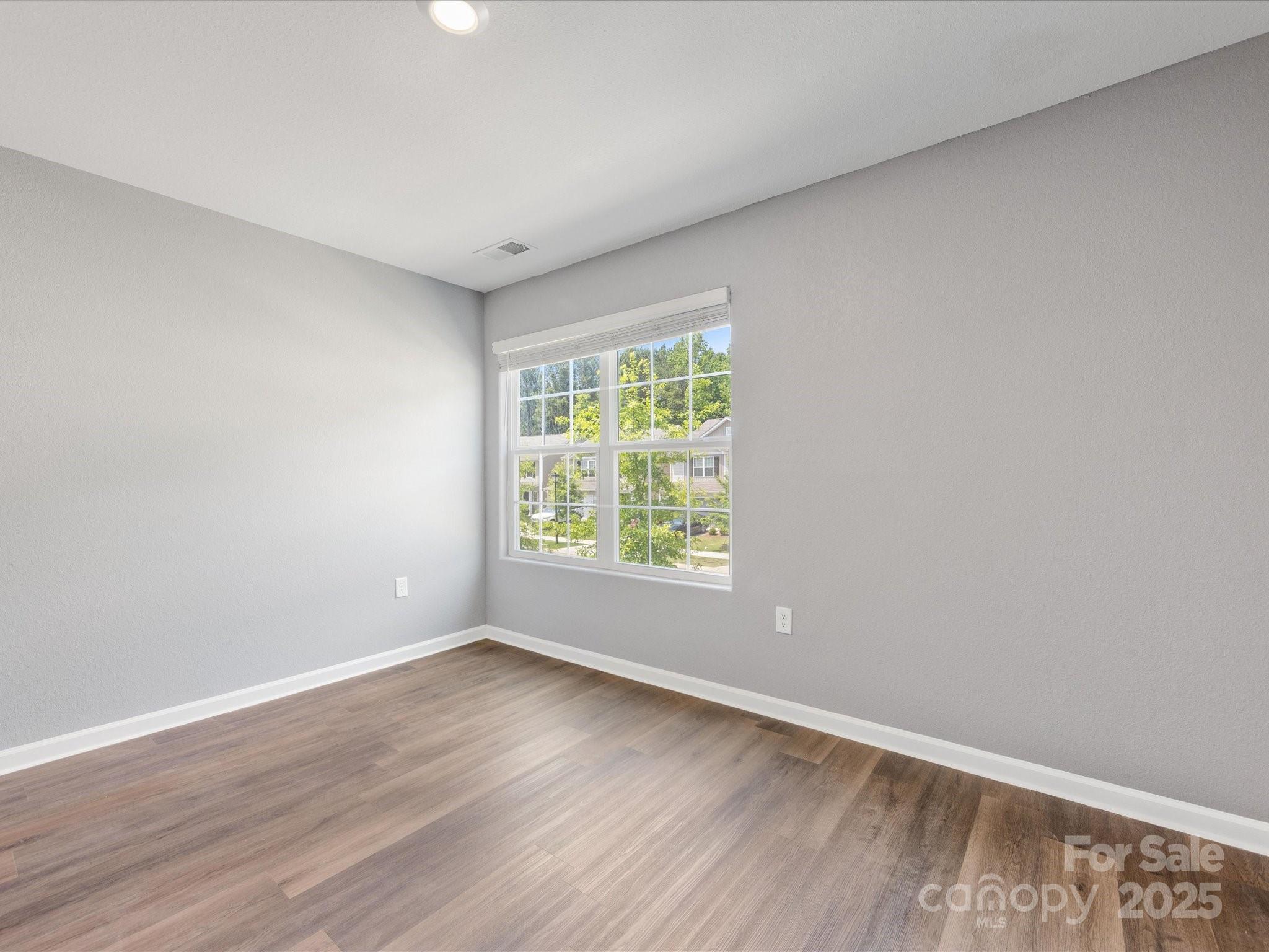 9136 Creedmore Hills Drive Charlotte, NC 28214 - Photo 38 of 48 a view of an empty room with wooden floor and a window
