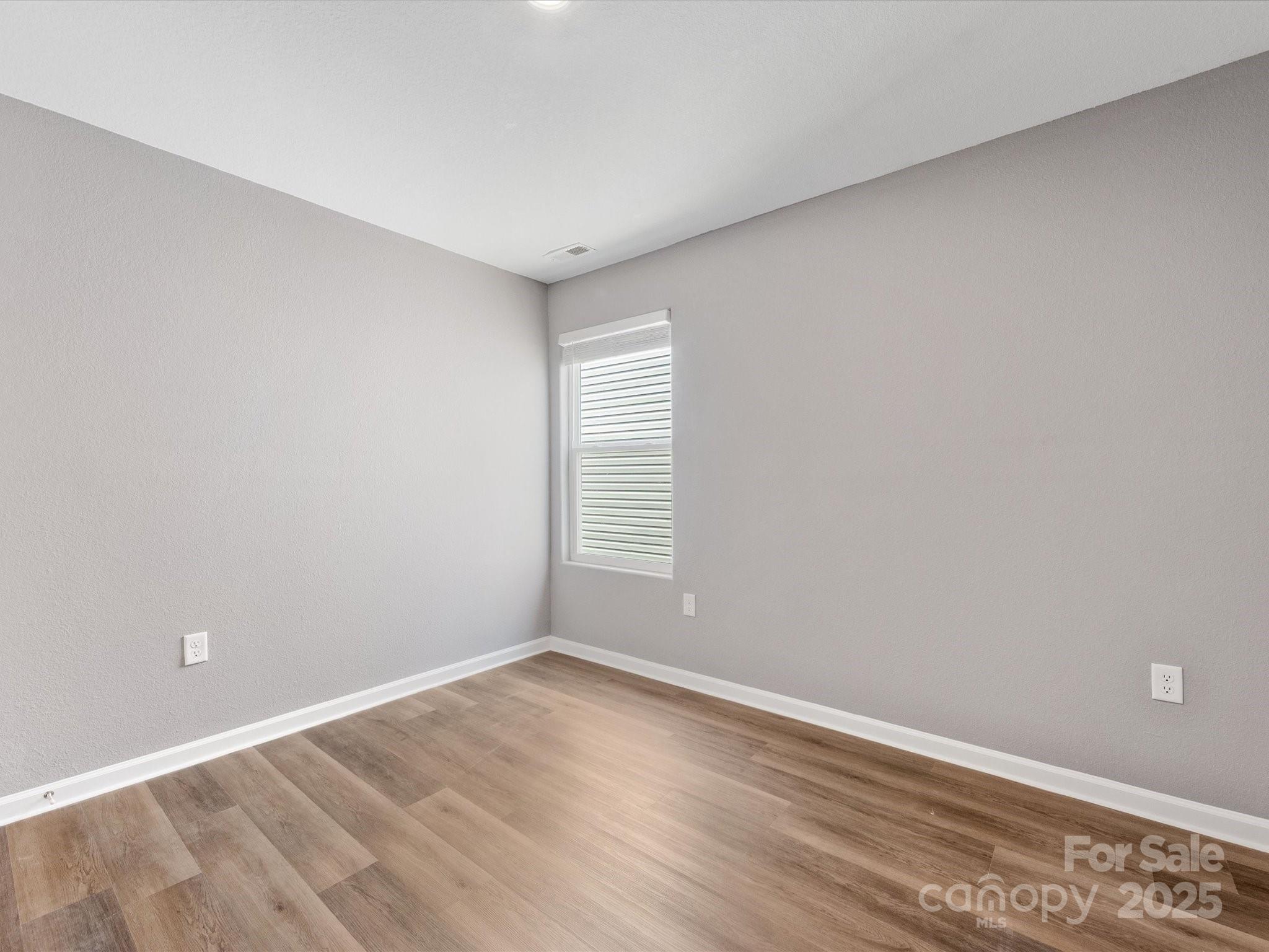 9136 Creedmore Hills Drive Charlotte, NC 28214 - Photo 42 of 48 a view of an empty room with wooden floor and a window