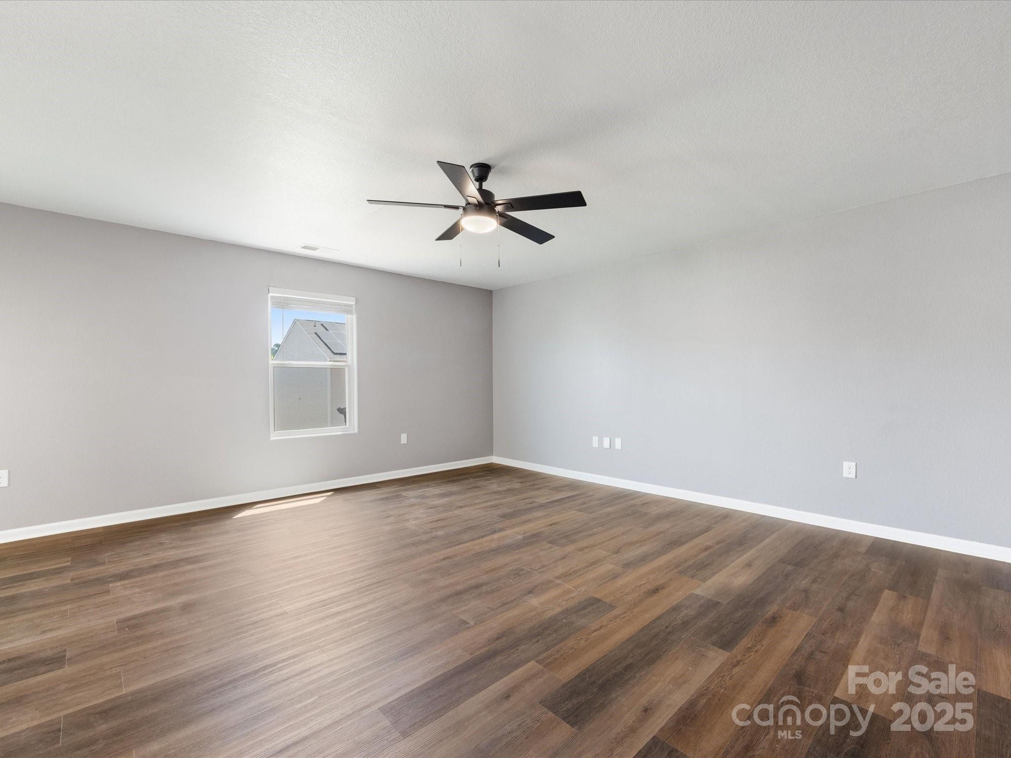 9136 Creedmore Hills Drive Charlotte, NC 28214 - Photo 10 of 48 an empty room with wooden floor and ceiling fan
