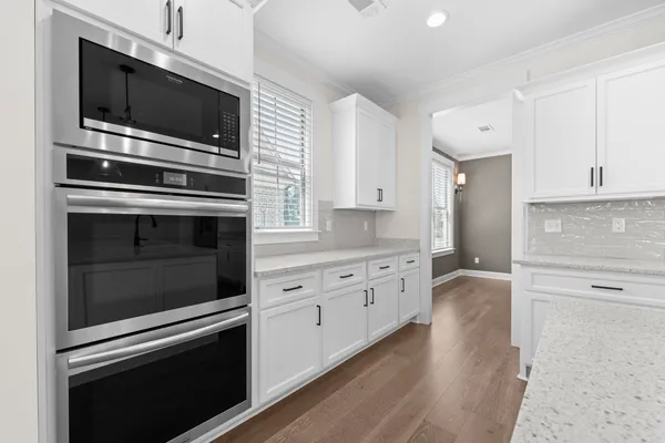 a kitchen with granite countertop cabinets stainless steel appliances and wooden floor