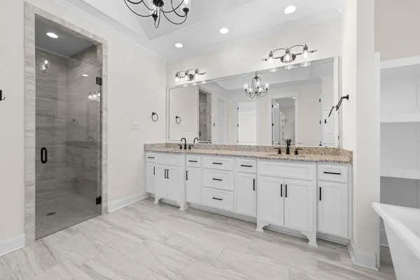 a bathroom with a double vanity sink mirror and shower