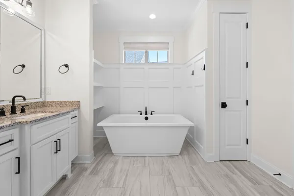 a bathroom with a tub sink and mirror