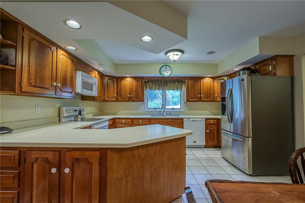 282 Alpine Heights Road Champion, PA 15622 - Photo 8 of 25 a kitchen with stainless steel appliances granite countertop a refrigerator a sink a stove a dining table and chairs with wooden floor