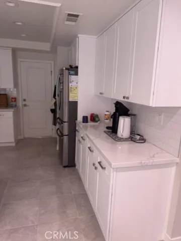 a kitchen with refrigerator and cabinets