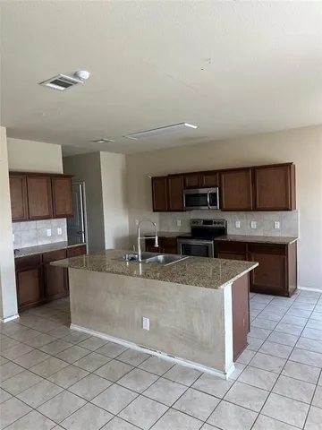 a large kitchen with stainless steel appliances and a sink