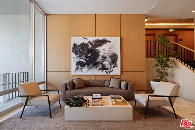 a living room with furniture and a painting on the wall
