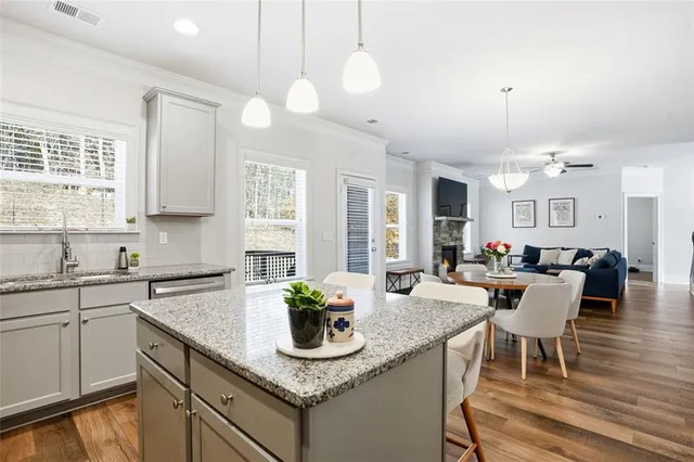 a view of a dining room and livingroom with furniture wooden floor a chandelier