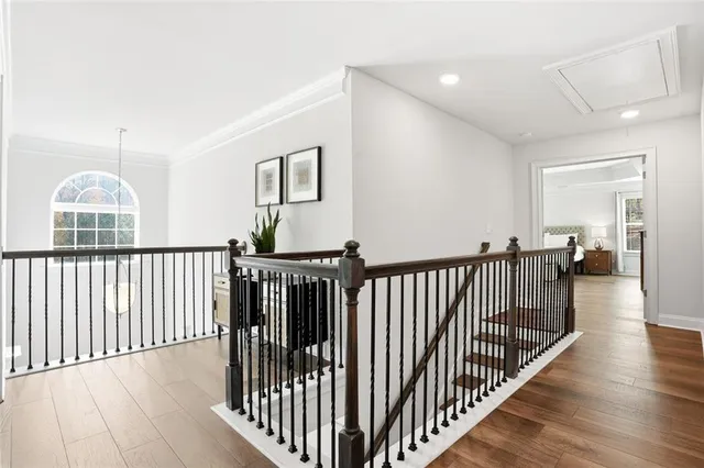 a view of a hallway with wooden floor and windows