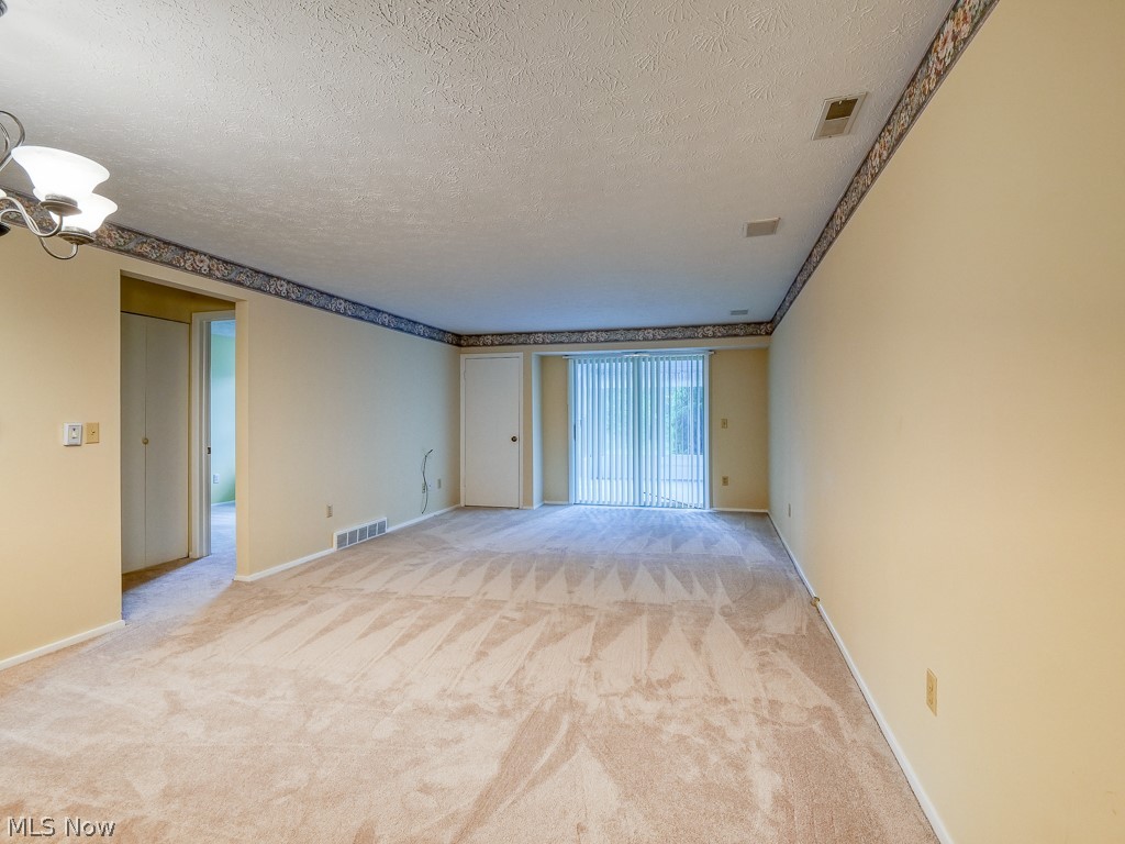 8941 West Ridge Road, Unit A Elyria, OH 44035 - Photo 18 of 30 room featuring a chandelier, light carpet, and a textured ceiling