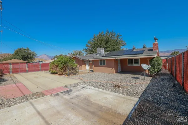 a view of a house with a yard and potted plants