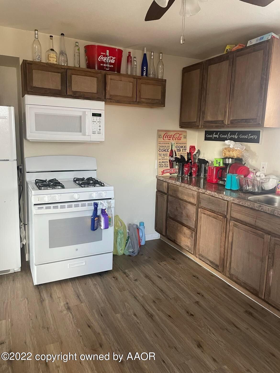 4213 South Polk Street Amarillo, TX 79110 - Photo 4 of 7 a kitchen with stainless steel appliances wooden floors and wooden cabinets