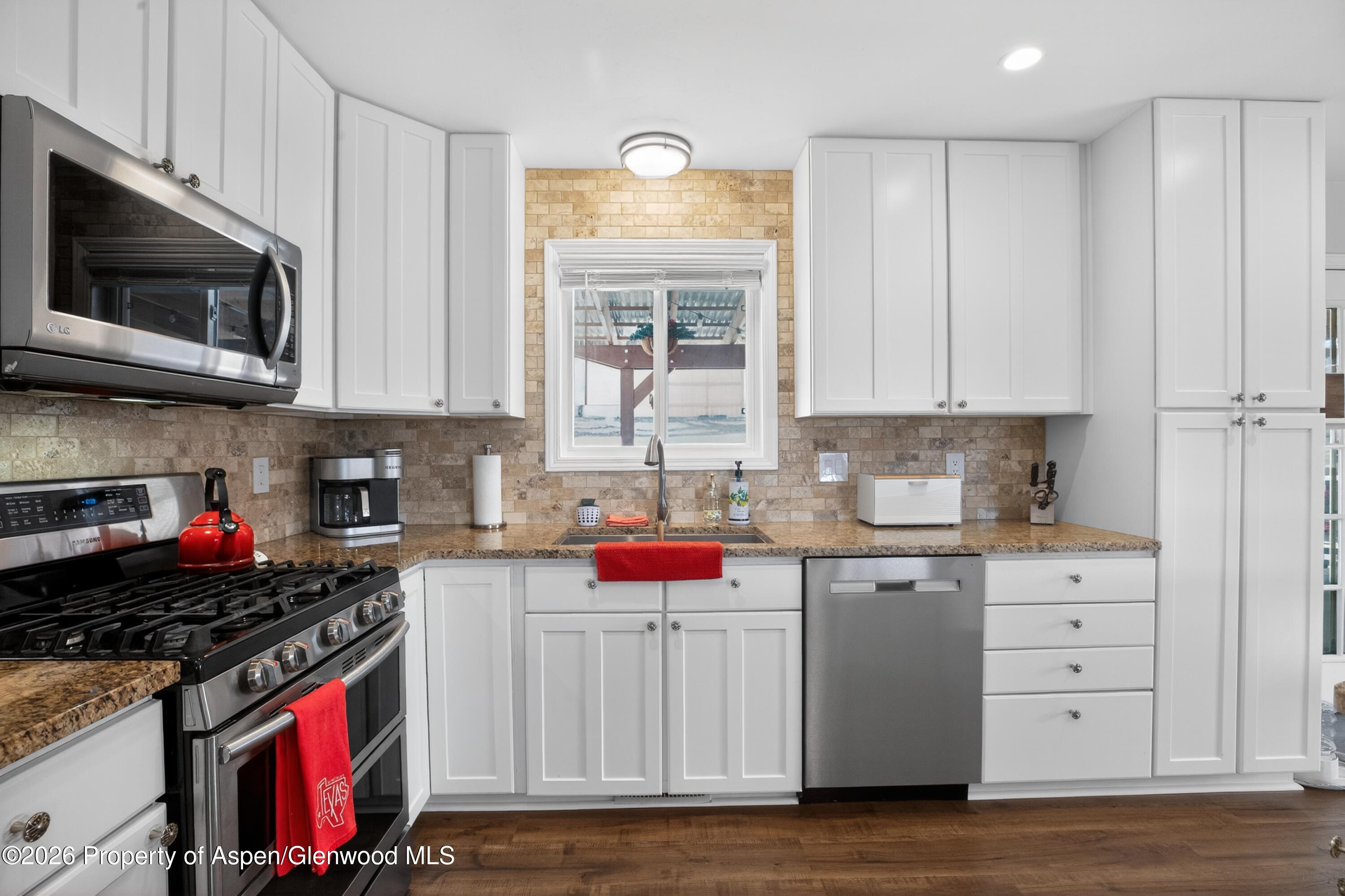 1310 Dogwood Drive Rifle, CO 81650 - Photo 3 of 49 a kitchen with stainless steel appliances granite countertop a stove and a microwave