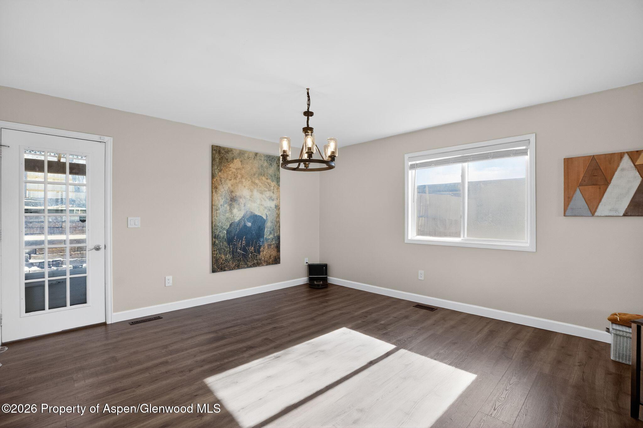 1310 Dogwood Drive Rifle, CO 81650 - Photo 7 of 49 a view of an empty room with wooden floor and a window