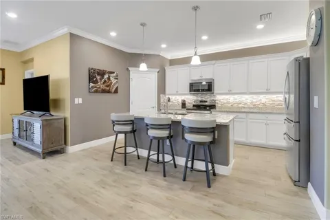 a kitchen with stainless steel appliances granite countertop a stove top oven a sink a refrigerator and a microwave