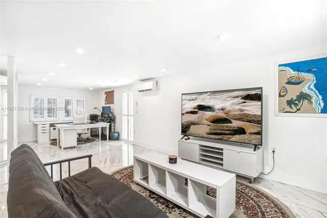 a living room with stainless steel appliances kitchen island granite countertop furniture and a rug