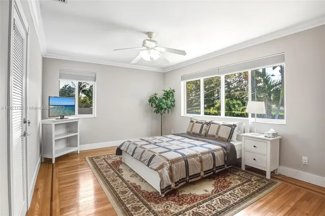 a bedroom with a large bed a chandelier and windows