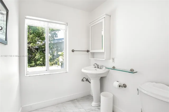 a bathroom with a sink a toilet and a mirror
