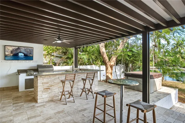 a view of an outdoor kitchen with a table and chairs