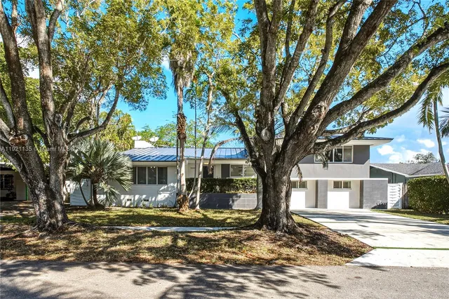 a view of a white house that has a tree in it