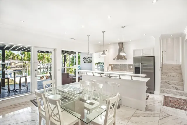 a view of a kitchen with stainless steel appliances kitchen island granite countertop a table and chairs