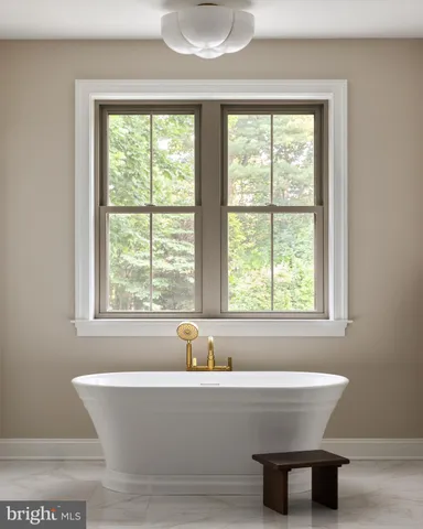 a white bath tub sitting in a bathroom next to a window