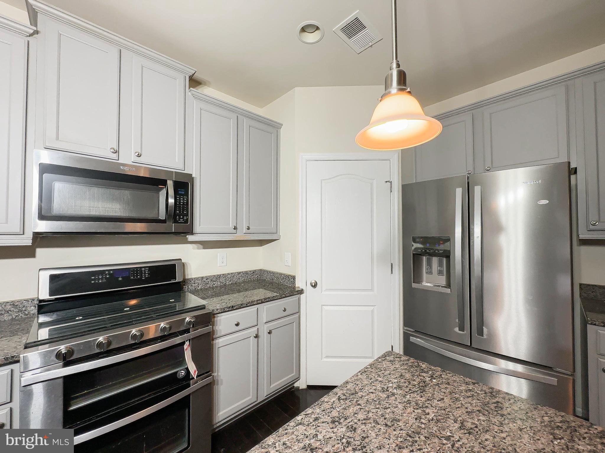 10202 Galaxy View Lane Lanham, MD 20706 - Photo 25 of 67 a kitchen with stainless steel appliances kitchen island granite countertop a refrigerator and a stove top oven