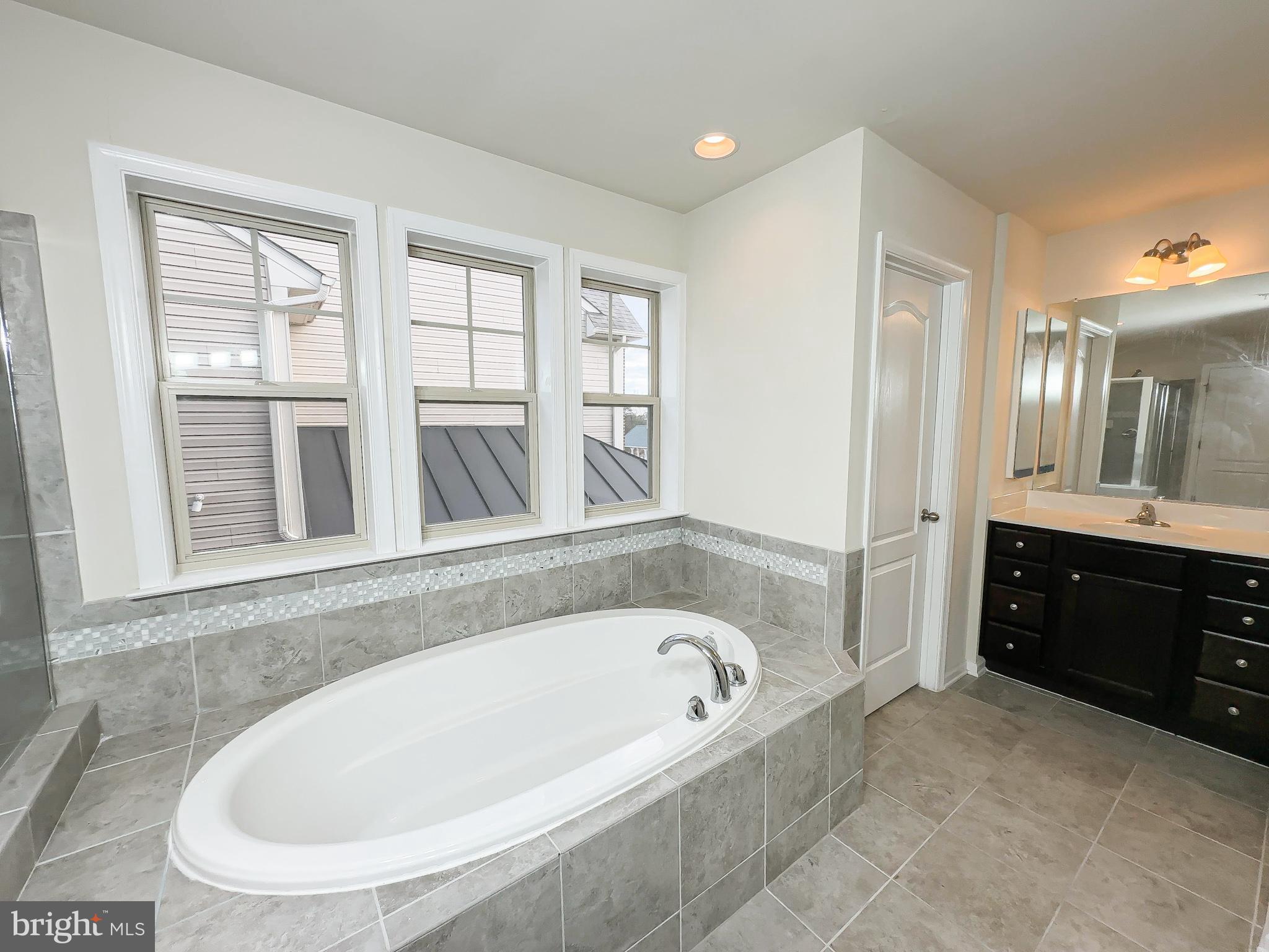 10202 Galaxy View Lane Lanham, MD 20706 - Photo 43 of 67 a bathroom with a bathtub and a sink