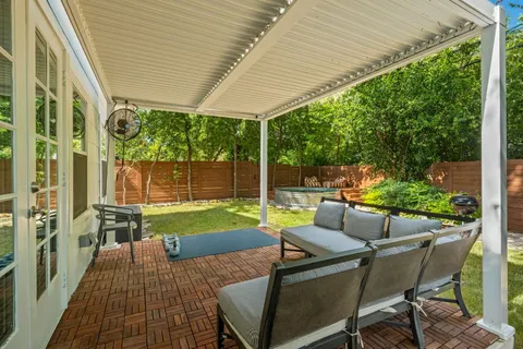 a view of a patio with table and chairs potted plants with floor to ceiling window