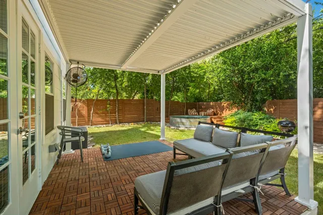 a view of a patio with table and chairs potted plants with floor to ceiling window