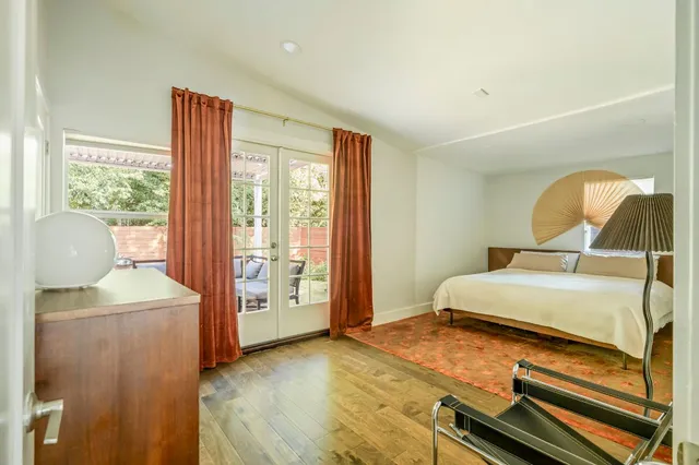 a bedroom with a bed and wooden floor