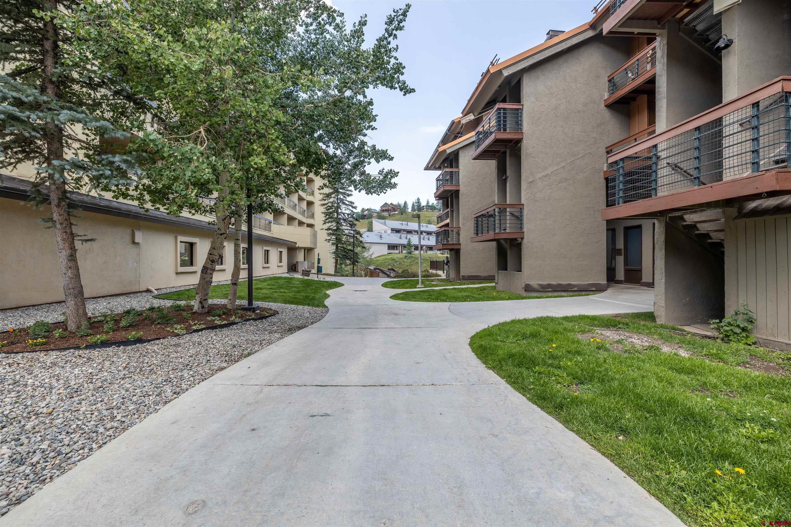 11 Emmons Road, Unit 430 Crested Butte, CO 81225 - Photo 26 of 27 a view of a house with brick walls plants and large tree