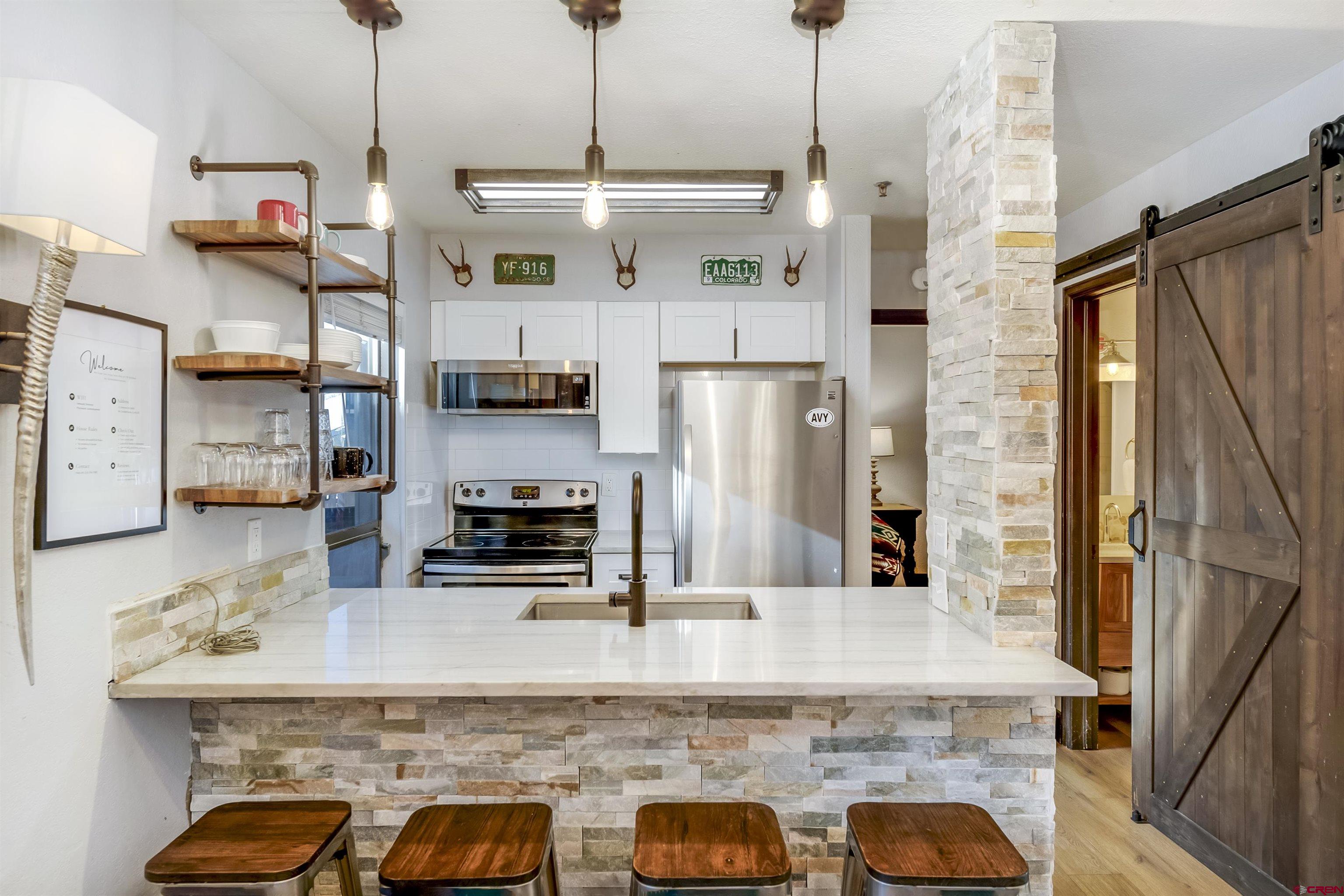 11 Emmons Road, Unit 430 Crested Butte, CO 81225 - Photo 5 of 27 a kitchen with kitchen island a counter space a sink appliances and cabinets