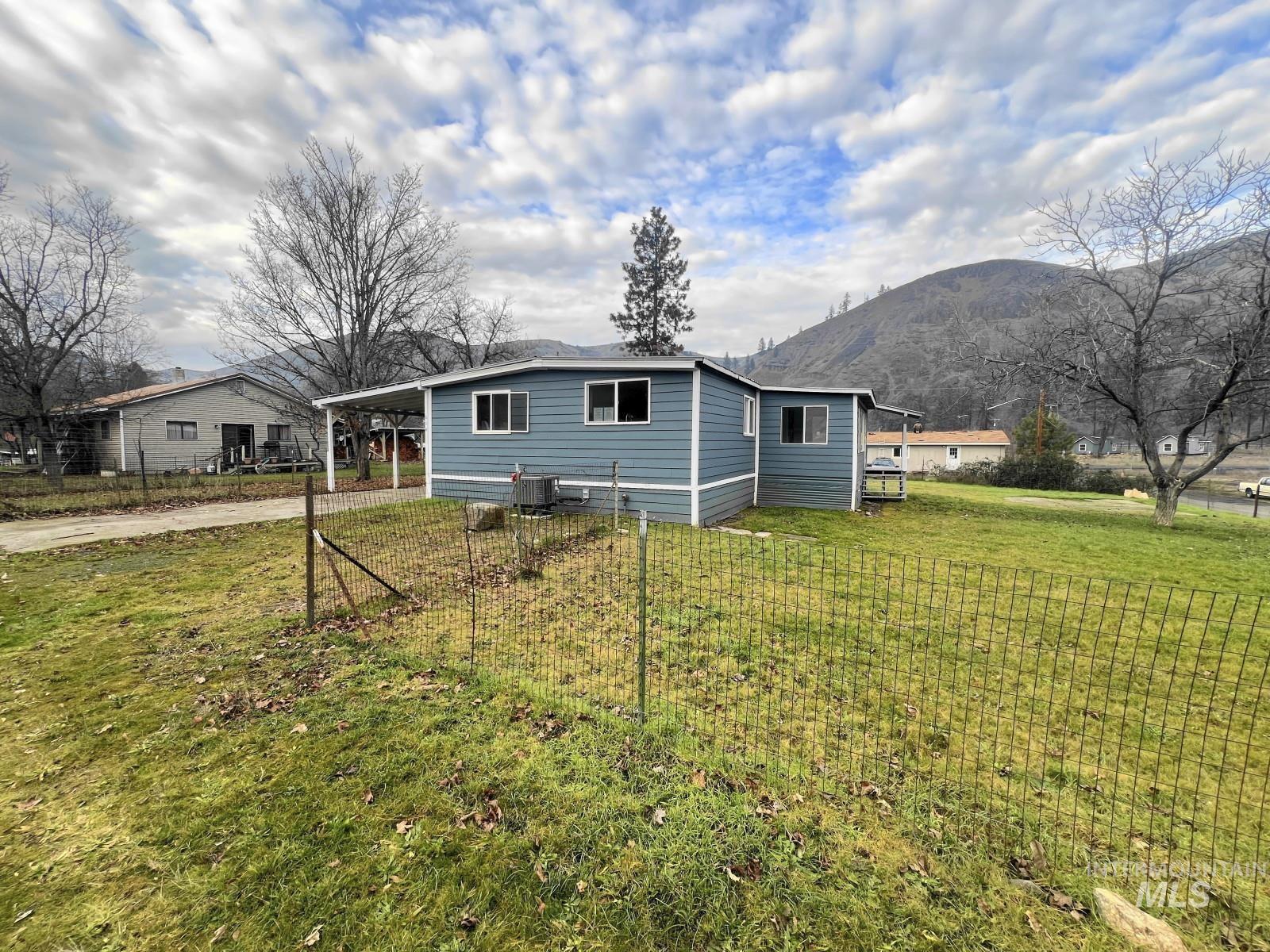 614 Pine Avenue Kooskia, ID 83539 - Photo 1 of 27 View of front of home with concrete driveway, a mountain view, and a carport