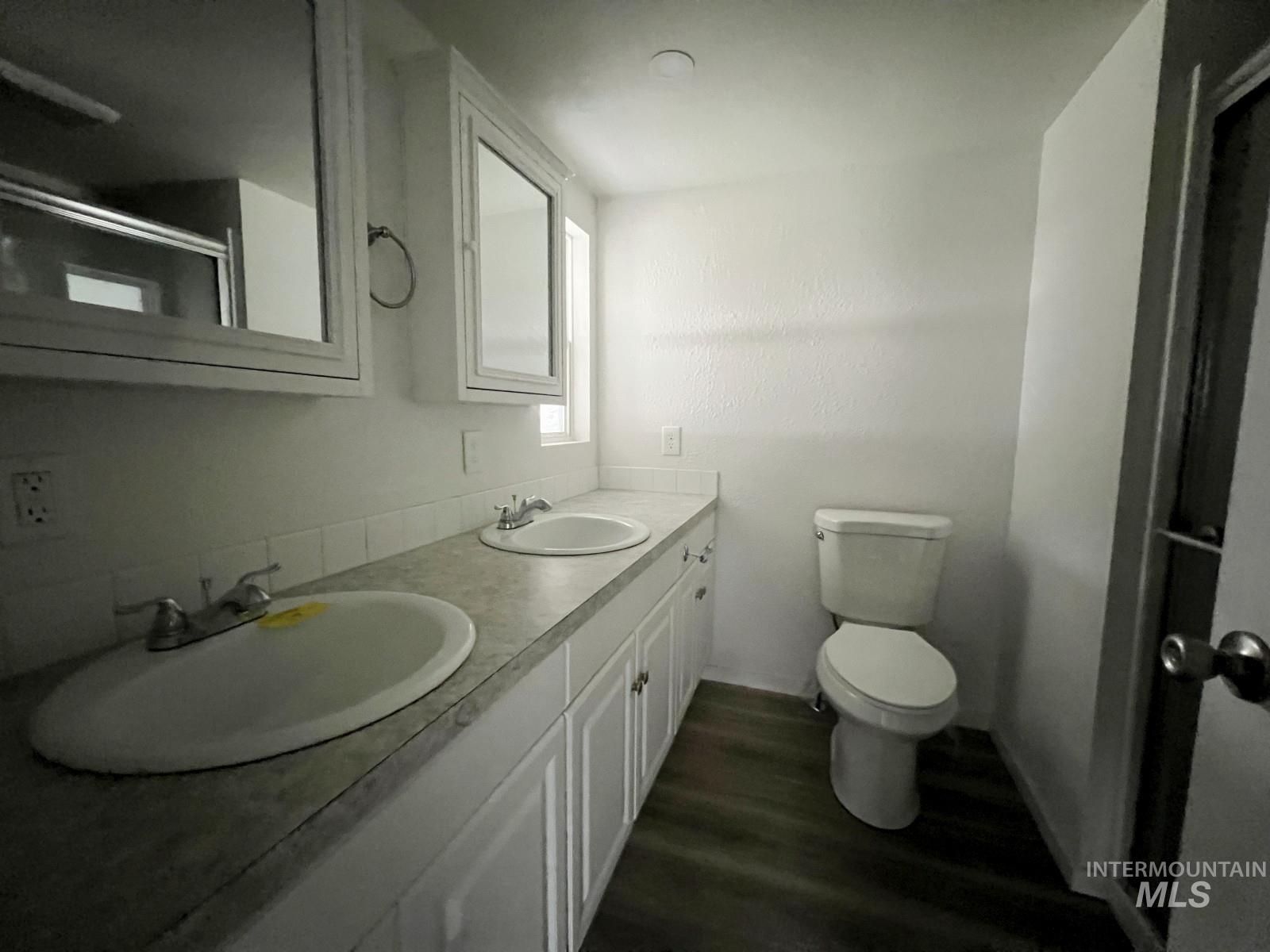 614 Pine Avenue Kooskia, ID 83539 - Photo 12 of 27 Bathroom featuring double vanity, dark wood-type flooring, and a shower with shower door