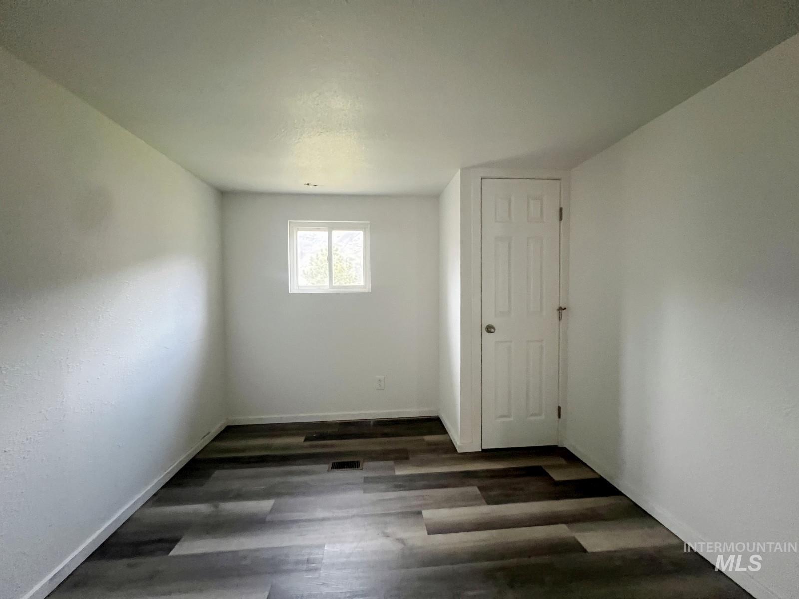 614 Pine Avenue Kooskia, ID 83539 - Photo 14 of 27 Unfurnished room featuring dark wood-style flooring and baseboards