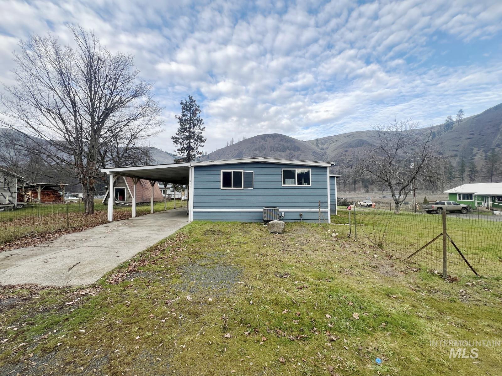 614 Pine Avenue Kooskia, ID 83539 - Photo 19 of 27 View of front facade featuring driveway, a carport, and a mountain view
