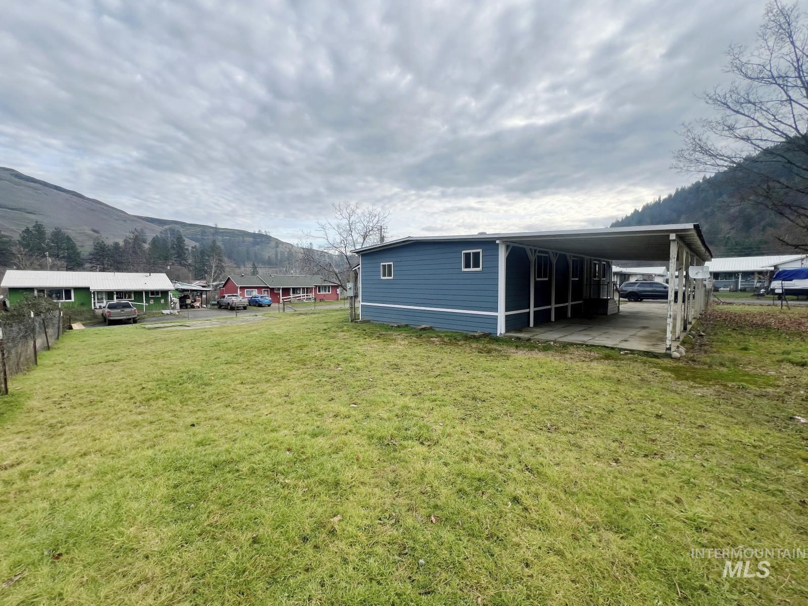 614 Pine Avenue Kooskia, ID 83539 - Photo 23 of 27 View of yard with a mountain view and an attached carport