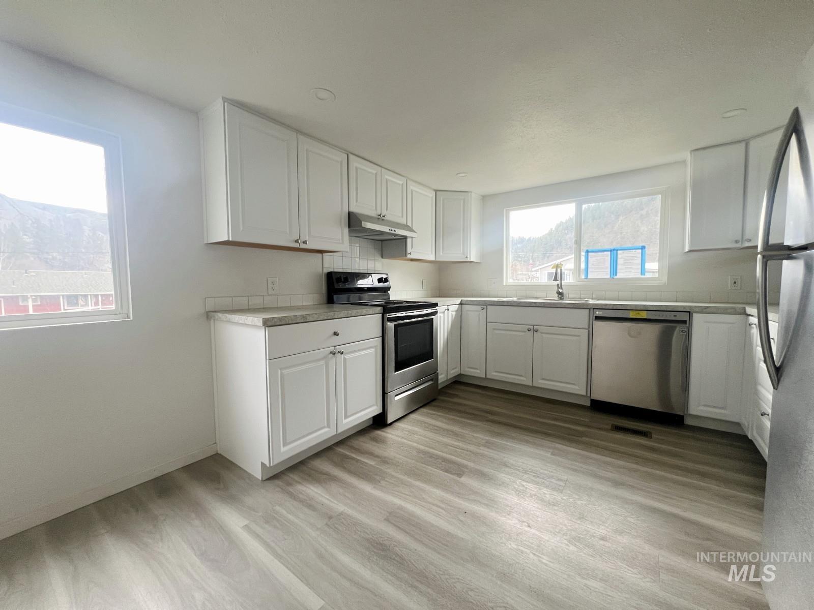 614 Pine Avenue Kooskia, ID 83539 - Photo 8 of 27 Kitchen with appliances with stainless steel finishes, light countertops, white cabinetry, and light wood-type flooring